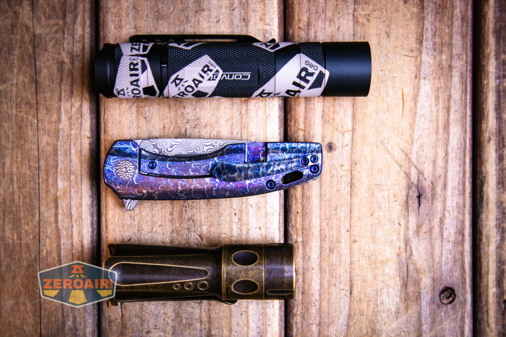 Kansept Cassowary titanium flipper knife with two standard sized flashlights