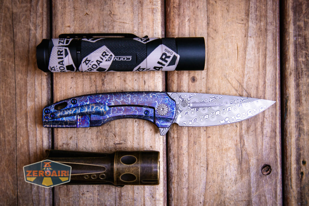 Kansept Cassowary titanium flipper knife with two standard sized flashlights