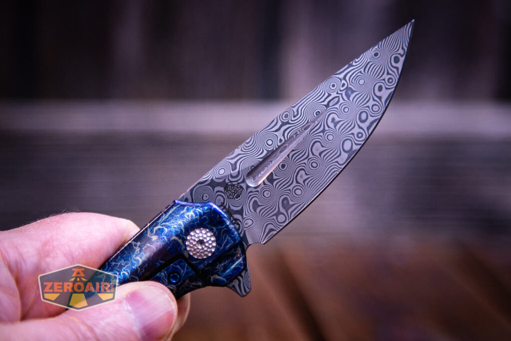 Kansept Cassowary titanium flipper knife damascus detail