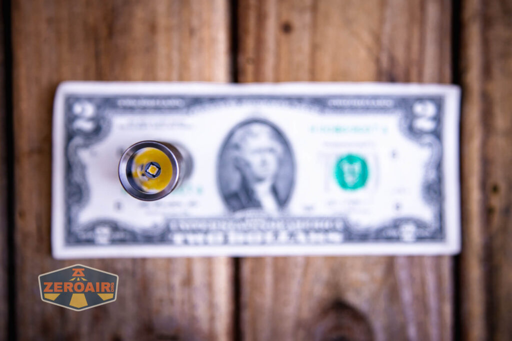 Tactile Turn Apollo flashlight on two dollar bill