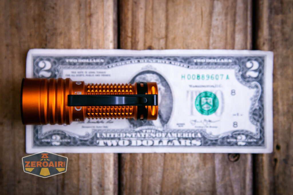 Olight Baton Turbo Orange flashlight on two dollar bill