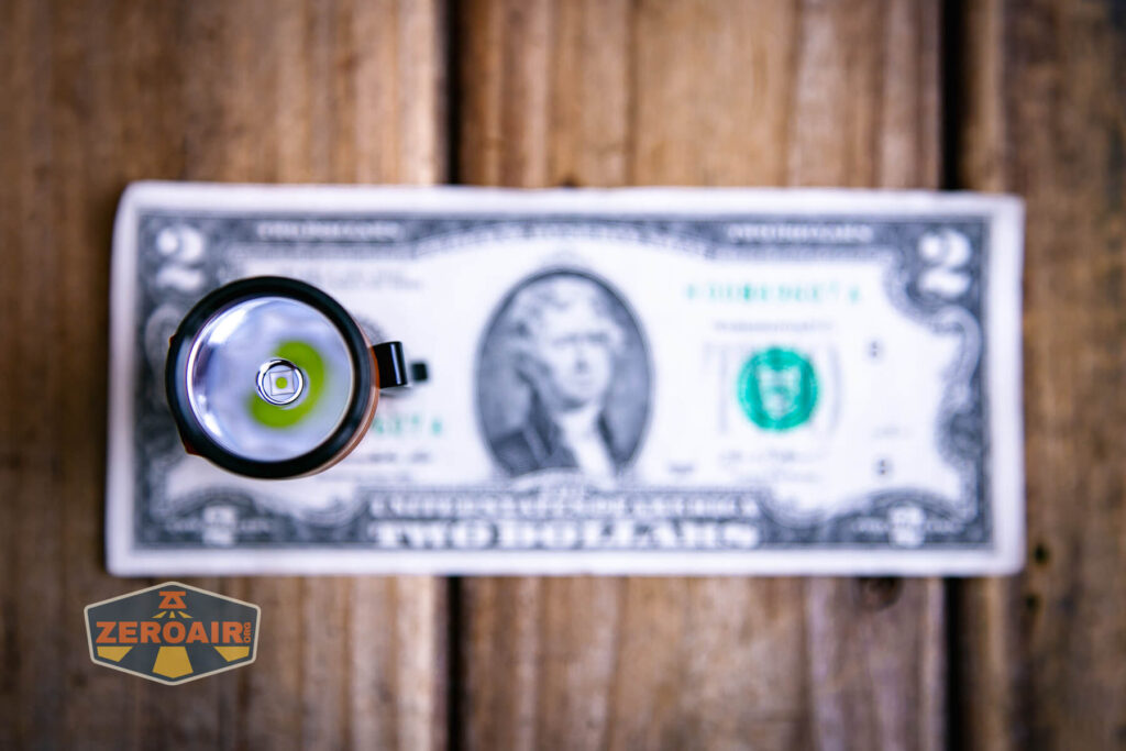 Olight Baton Turbo Orange flashlight on two dollar bill