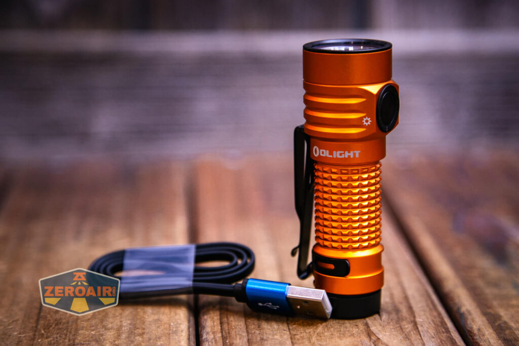 Olight Baton Turbo Orange flashlight on charging base/cable