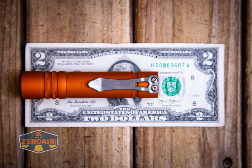 Focusworks EDC F3 Pumpkin Orange flashlight on a two dollar bill
