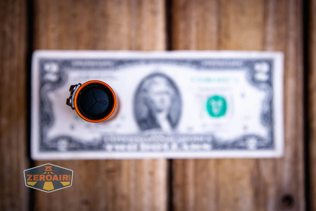 Focusworks EDC F3 Pumpkin Orange flashlight on a two dollar bill