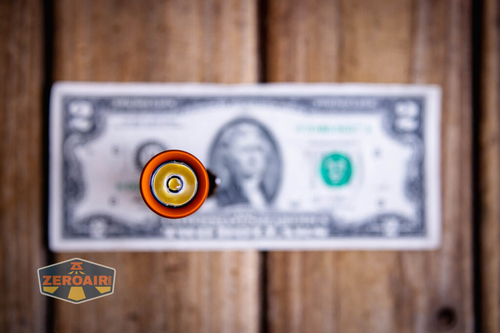 Focusworks EDC F3 Pumpkin Orange flashlight on a two dollar bill