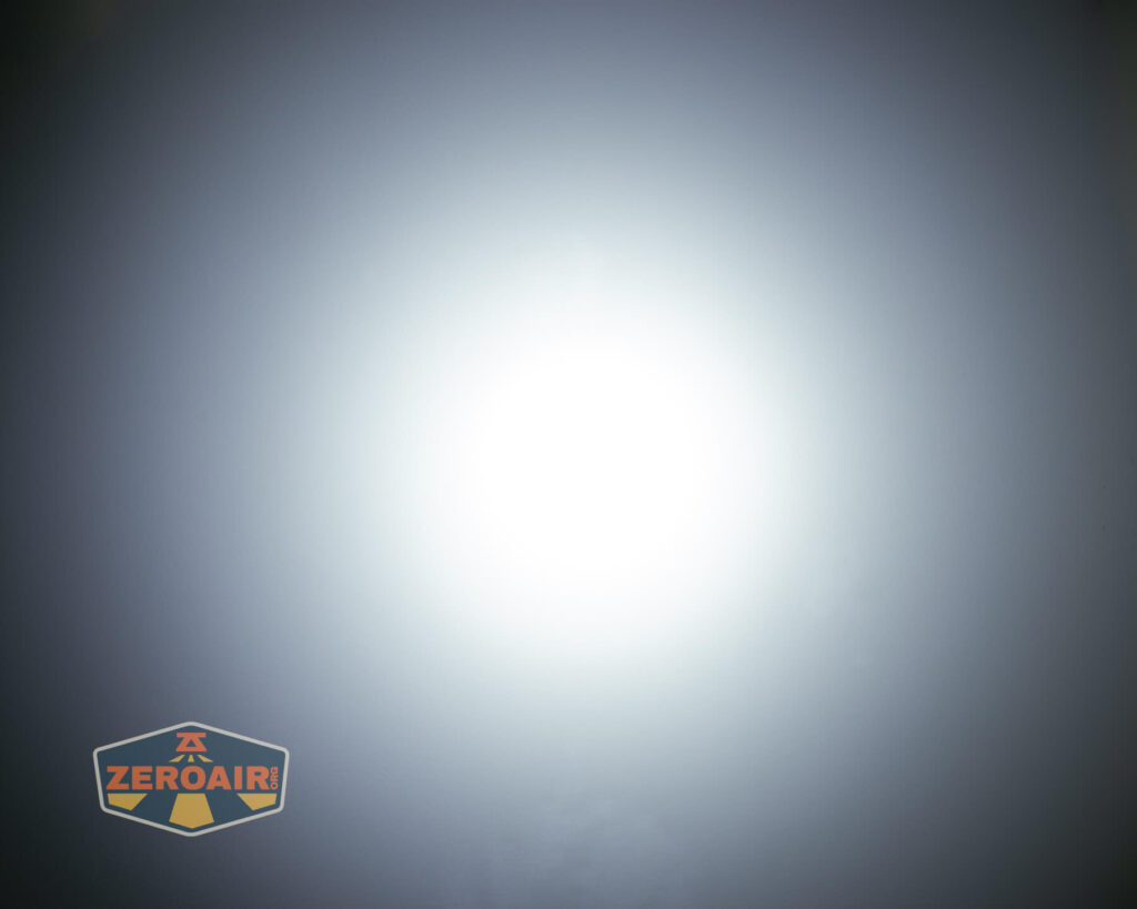 A bright white circular light source in the center of a dark gradient background, with a ZeroAir logo in the lower left corner.