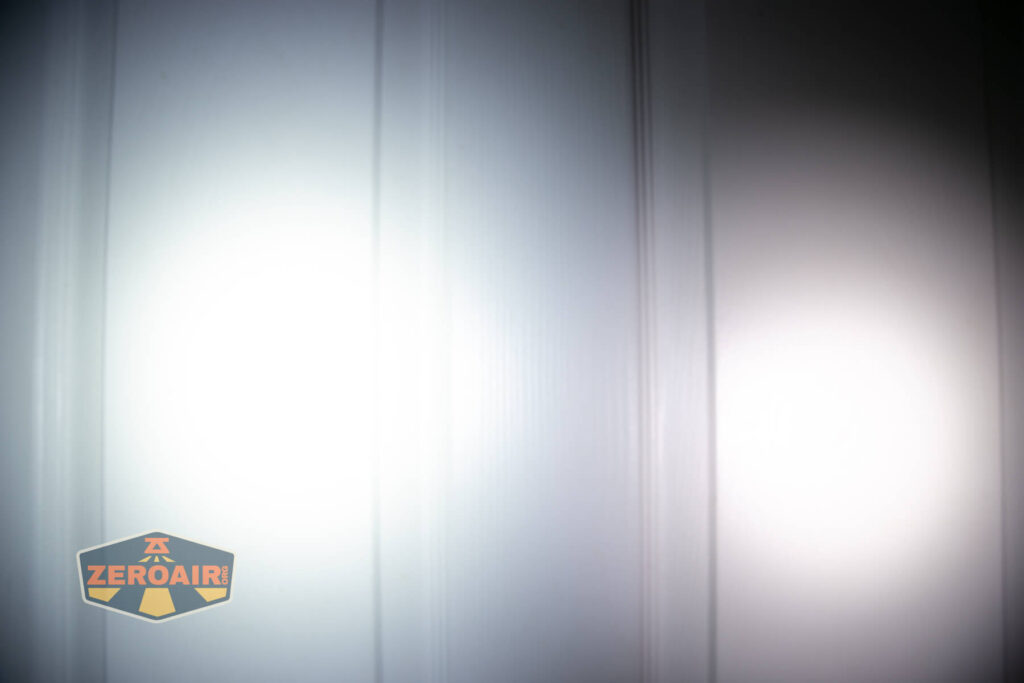 Two circular beams of light are projected onto a white panel door, creating overlapping illuminated areas. A ZeroAir logo appears in the bottom left corner of the image.