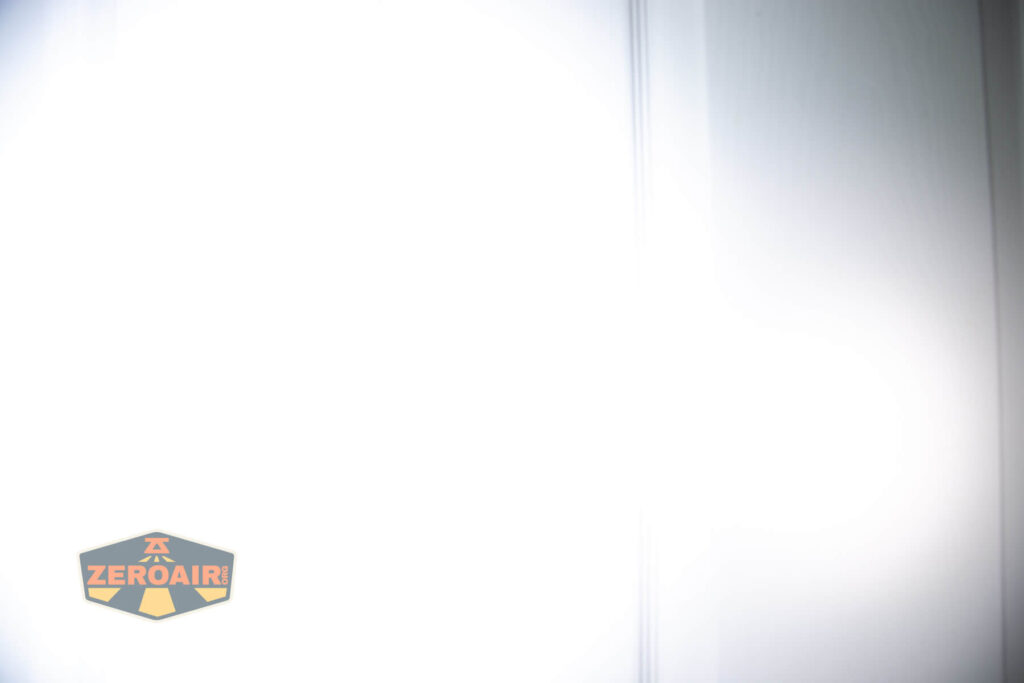 A bright white light fills most of the image, causing overexposure. On the bottom left, there is a logo with the word ZEROAIR in yellow and orange on a shield-shaped background.