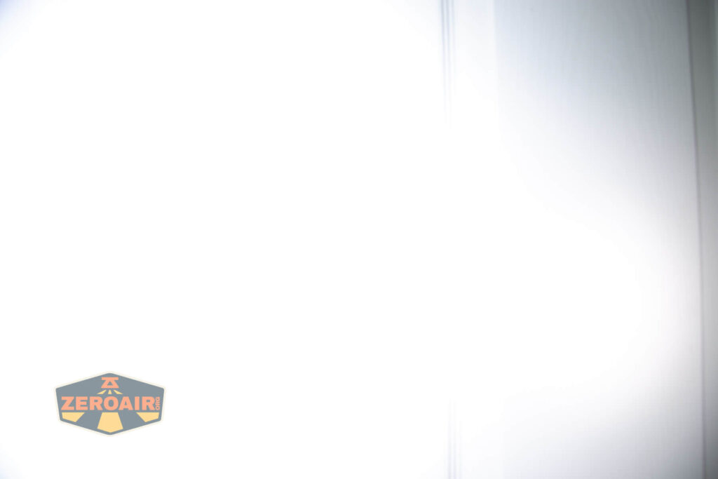 Brightly lit white surface with a vertical line on the right side and the ZeroAir logo in the lower left corner. The logo features the word ZeroAir on a shield-shaped emblem.