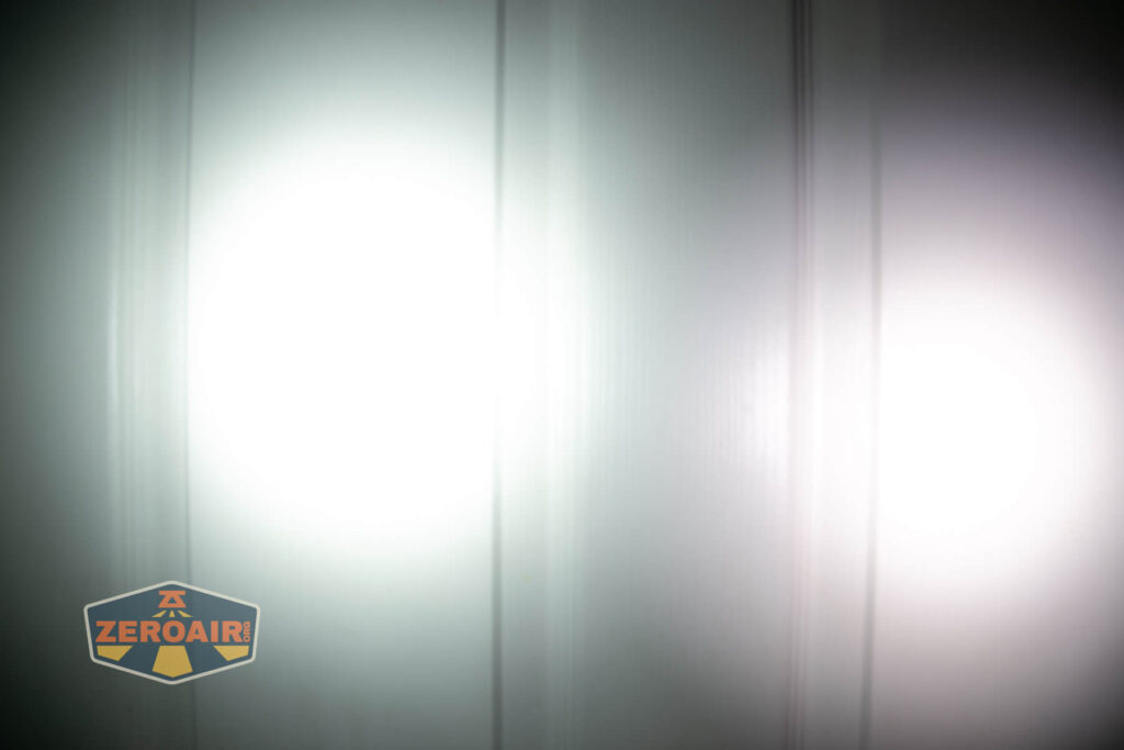 Nitecore HC65 UHE headlamp beamshots on door (at 1') compared to nichia 219b 4500K