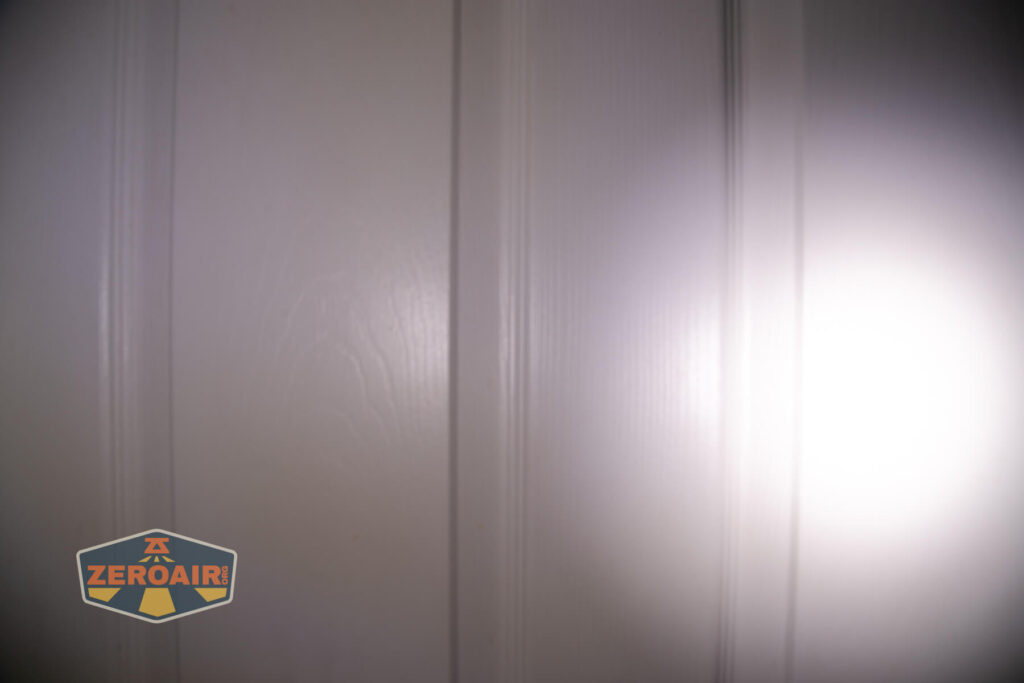 Nitecore HC65 UHE headlamp beamshots on door (at 1') compared to nichia 219b 4500K