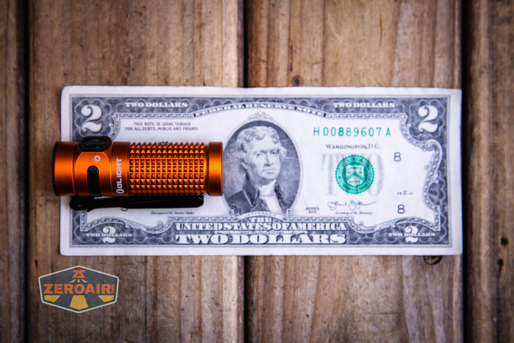 Olight Baton 4 Premium flashlight on a two dollar bill