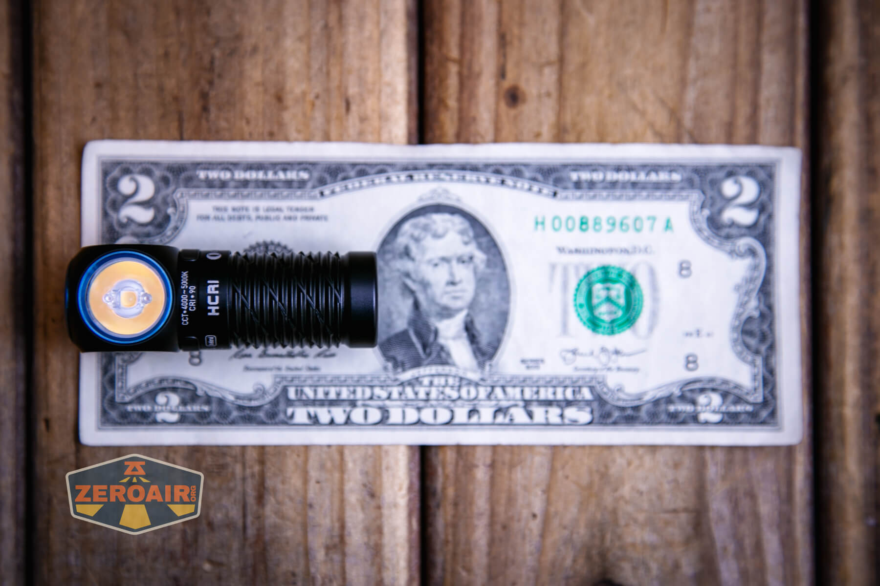 Olight Perun 3 Mini CRI headlamp on a two dollar bill