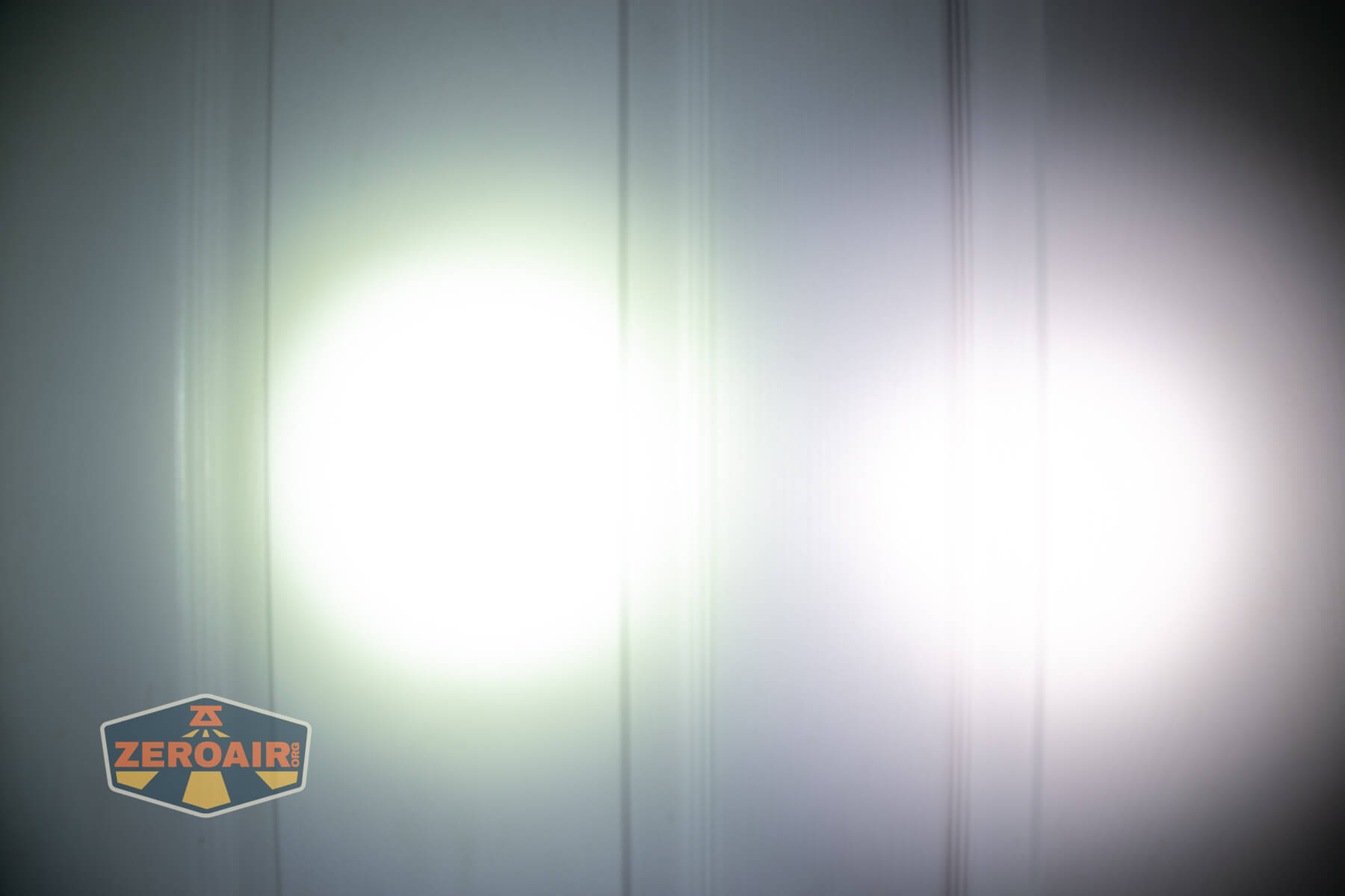 Olight Perun 3 Mini cool white headlamp beamshots on door (at 1') compared to nichia 219b 4500K