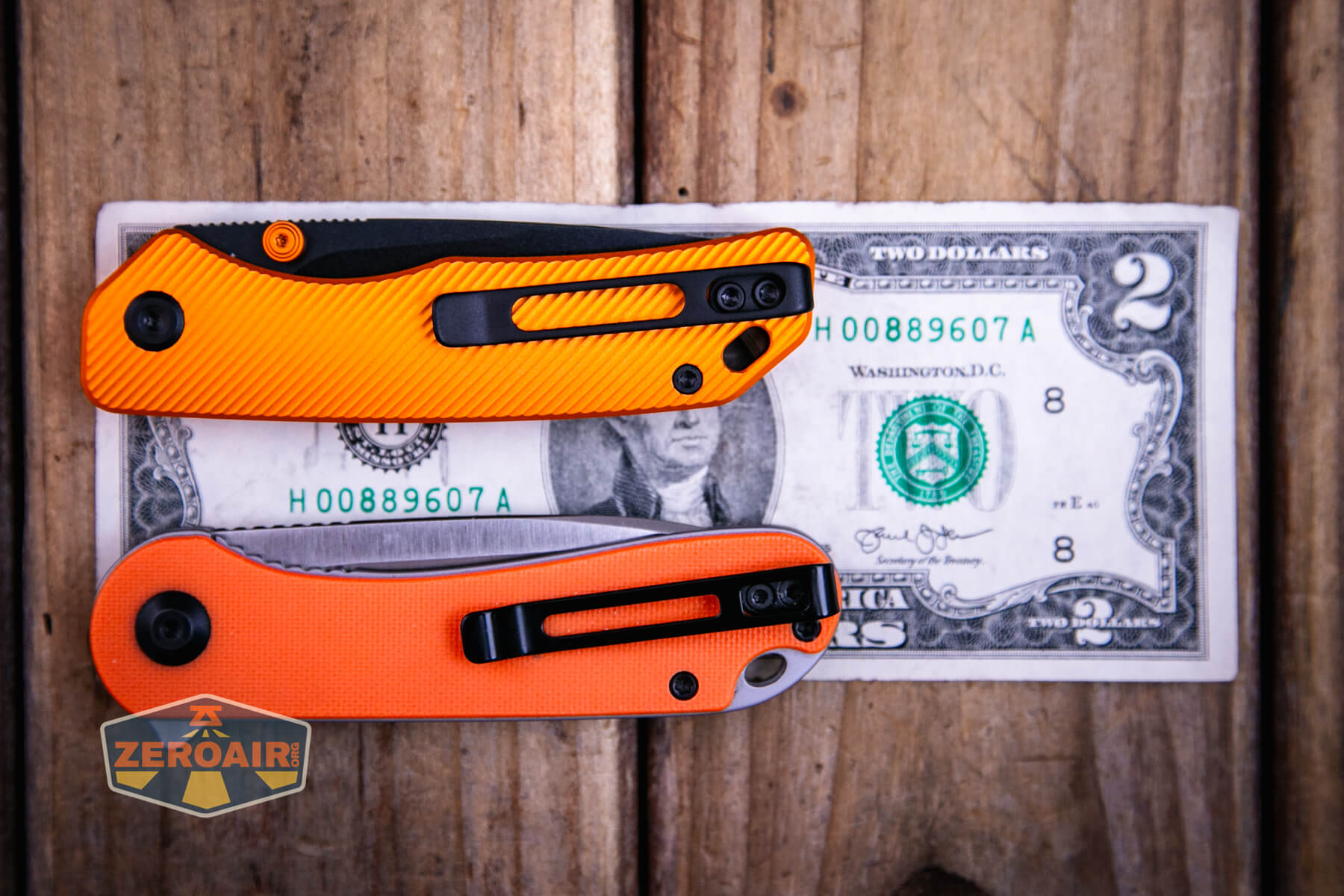 Vosteed Marten top liner lock knife on a two dollar bill with two standard sized flashlights