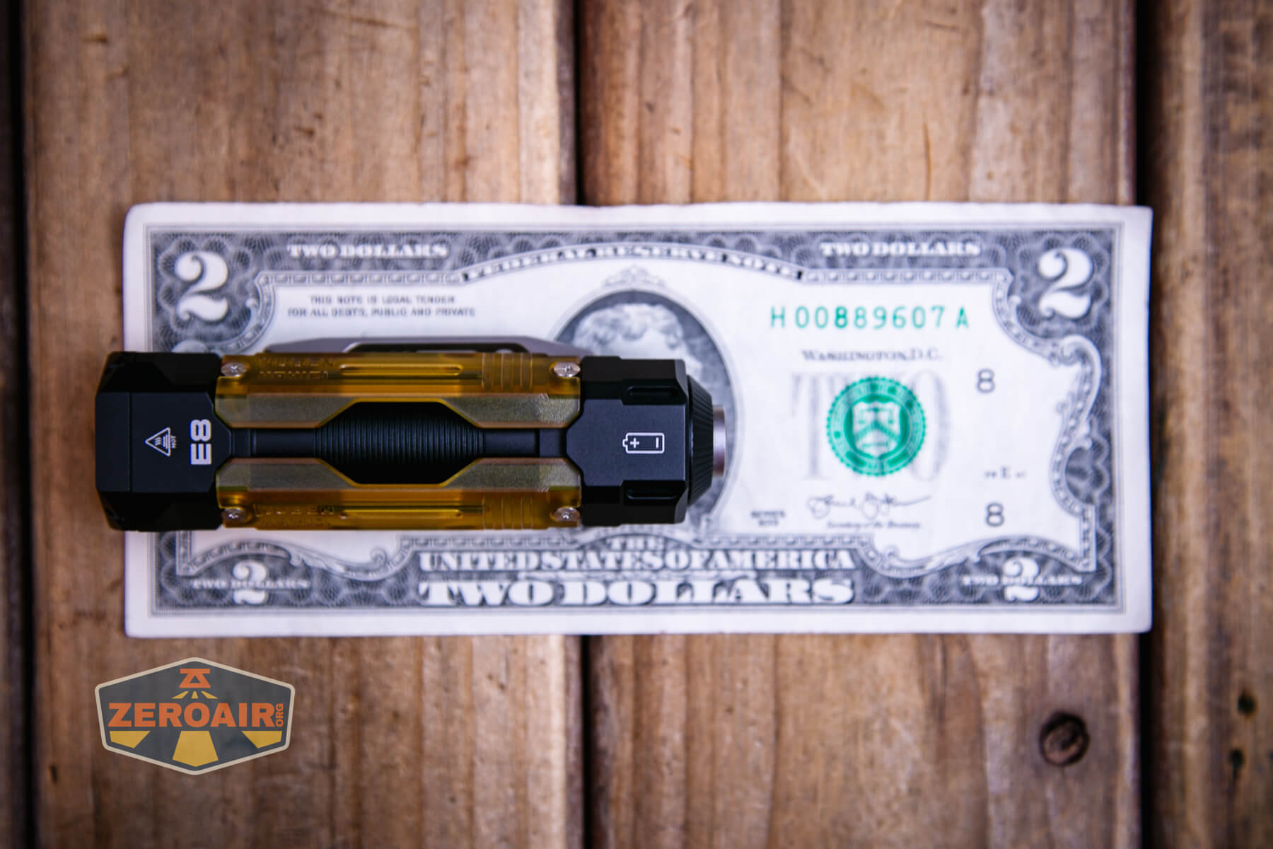Wuben E8 modular flashlight on a two dollar bill