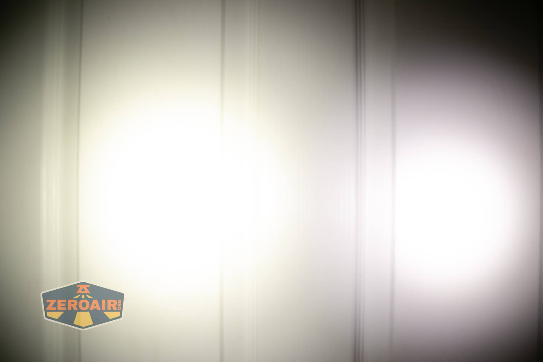 Wuben E8 modular flashlight beamshots on door (at 1') compared to nichia 219b 4500K