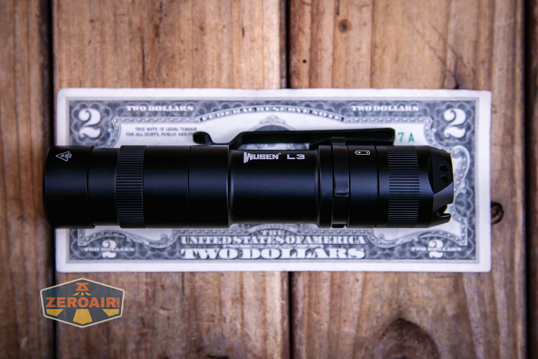 Wuben L3 flashlight on two dollar bill