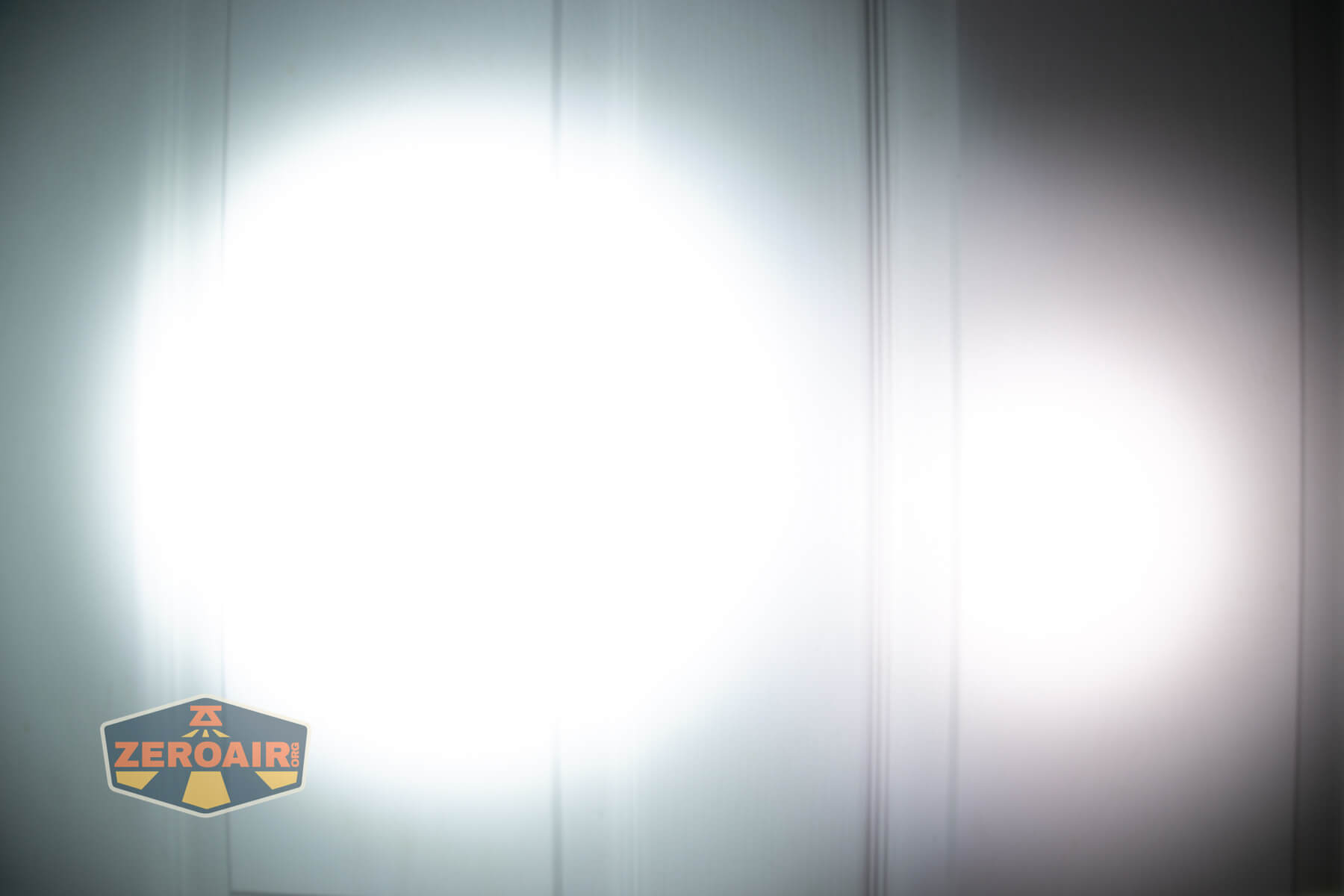 LoopGear LoopDot Pixel Display EDC flashlight beamshots on door (at 1') compared to nichia 219b 4500K