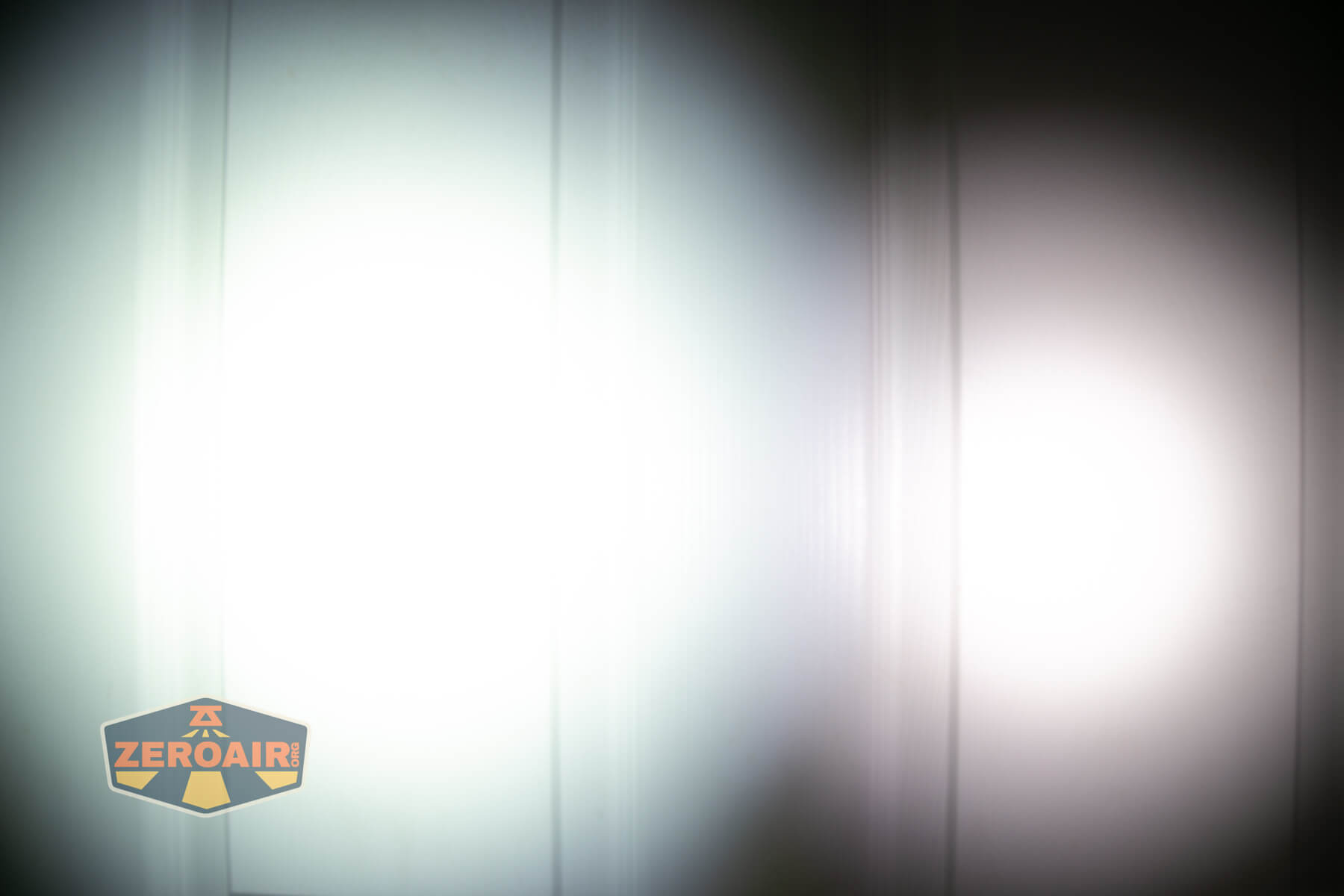 Nextorch TA22 20th anniversary penlight beamshots on door (at 1') compared to nichia 219b 4500K