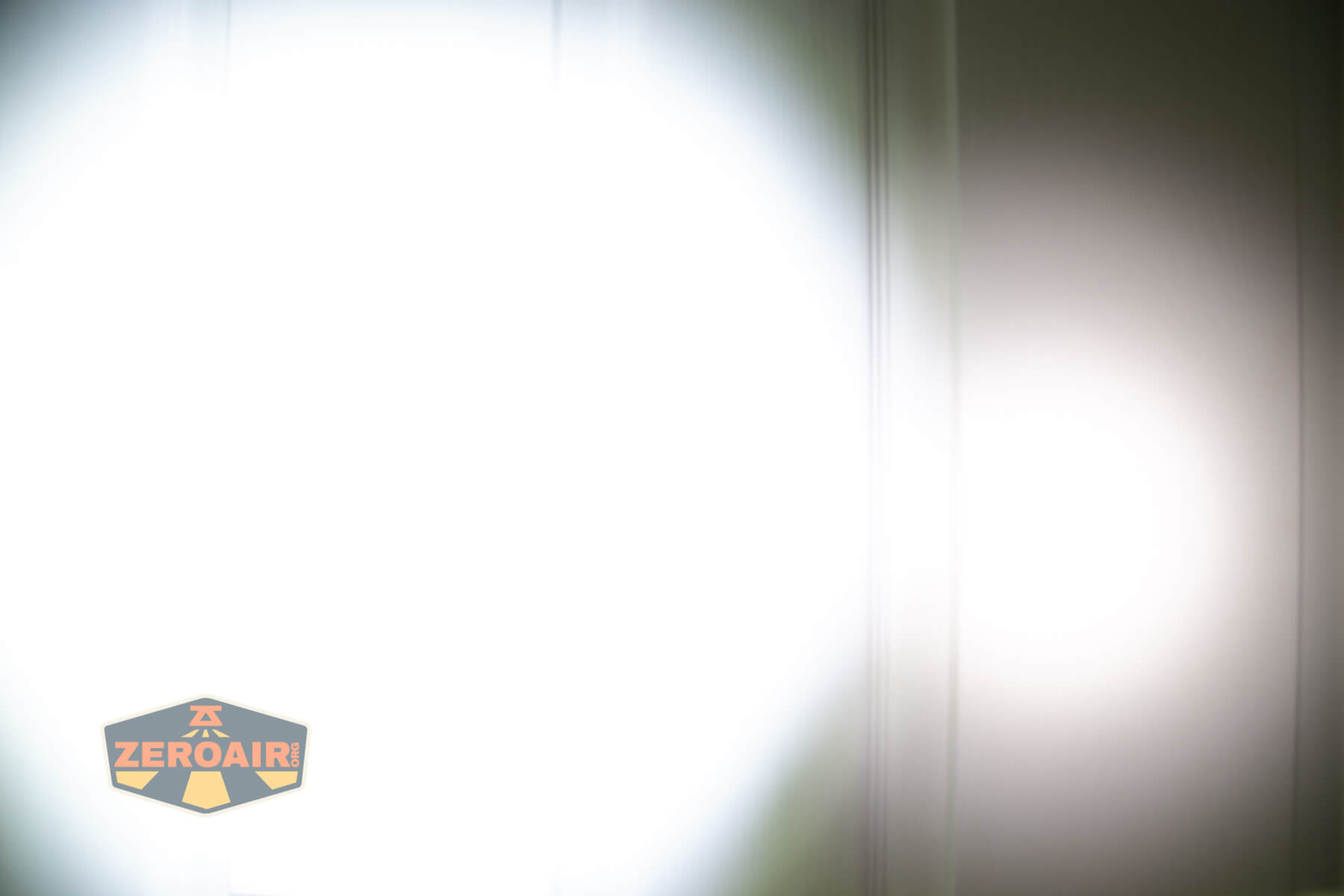 Nextorch TA22 20th anniversary penlight beamshots on door (at 1') compared to nichia 219b 4500K