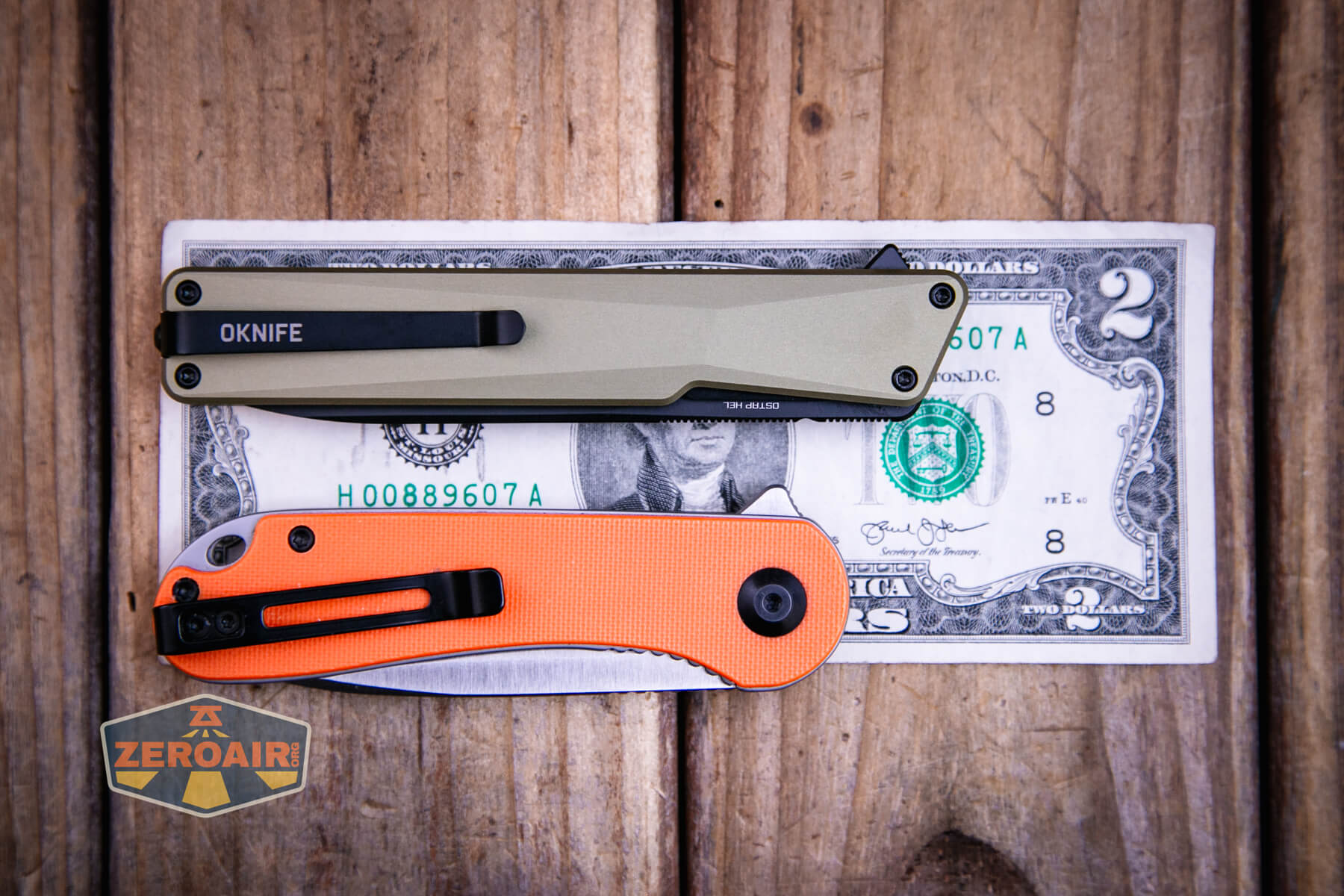 Olight Oknife Aion gentleman's folding knife on a two dollar bill compared to Civivi Elementum in orange