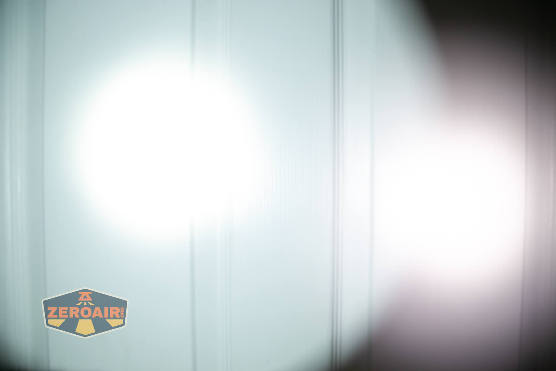 Armytek Dobermann Pro Max tactical flashlight beamshots on door (at 1') compared to nichia 219b 4500K