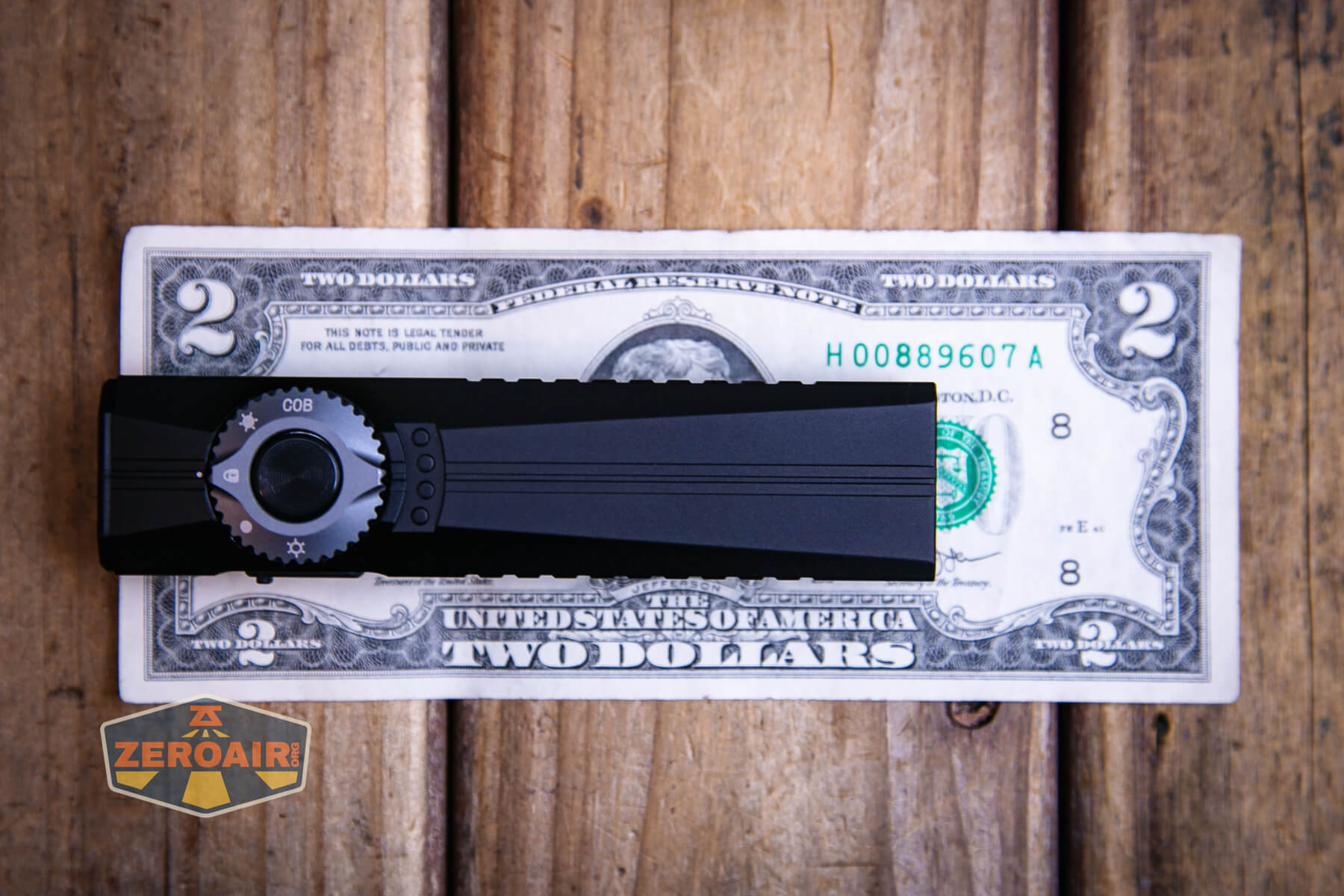 Cyansky Ark II EDC flat flashlight on two dollar bill