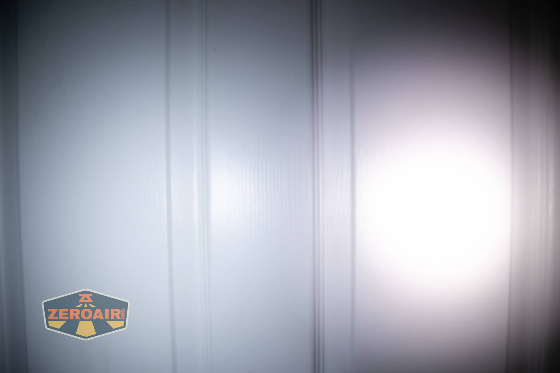 Cyansky Ark II EDC flat flashlight beamshots on door compared to nichia 219b