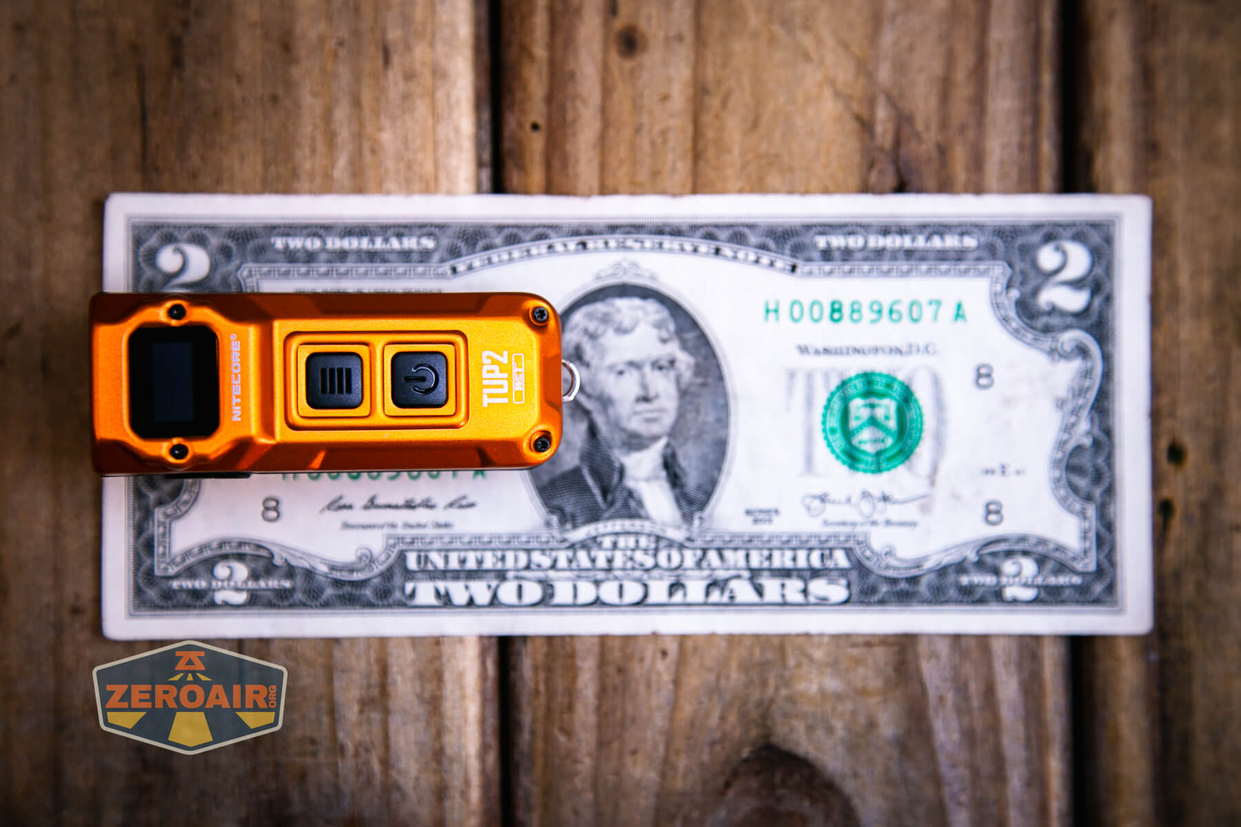 Nitecore TUP2 rechargeable keychain flashlight on two dollar bill
