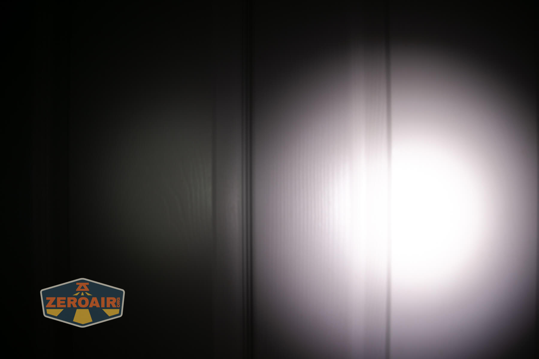 Nitecore TUP2 rechargeable keychain flashlight beamshots on door compared to nichia 219b