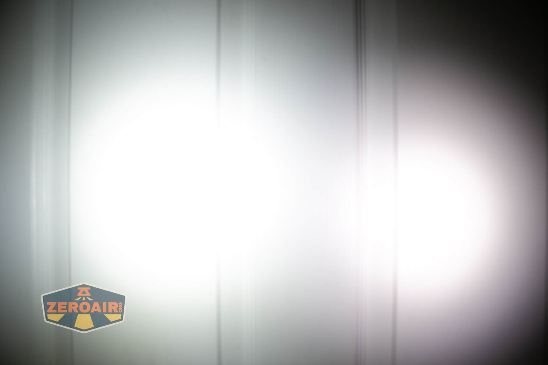 Nitecore TUP2 rechargeable keychain flashlight beamshots on door compared to nichia 219b