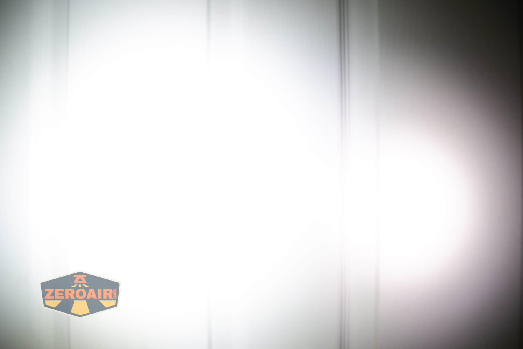 Nitecore TUP2 rechargeable keychain flashlight beamshots on door compared to nichia 219b