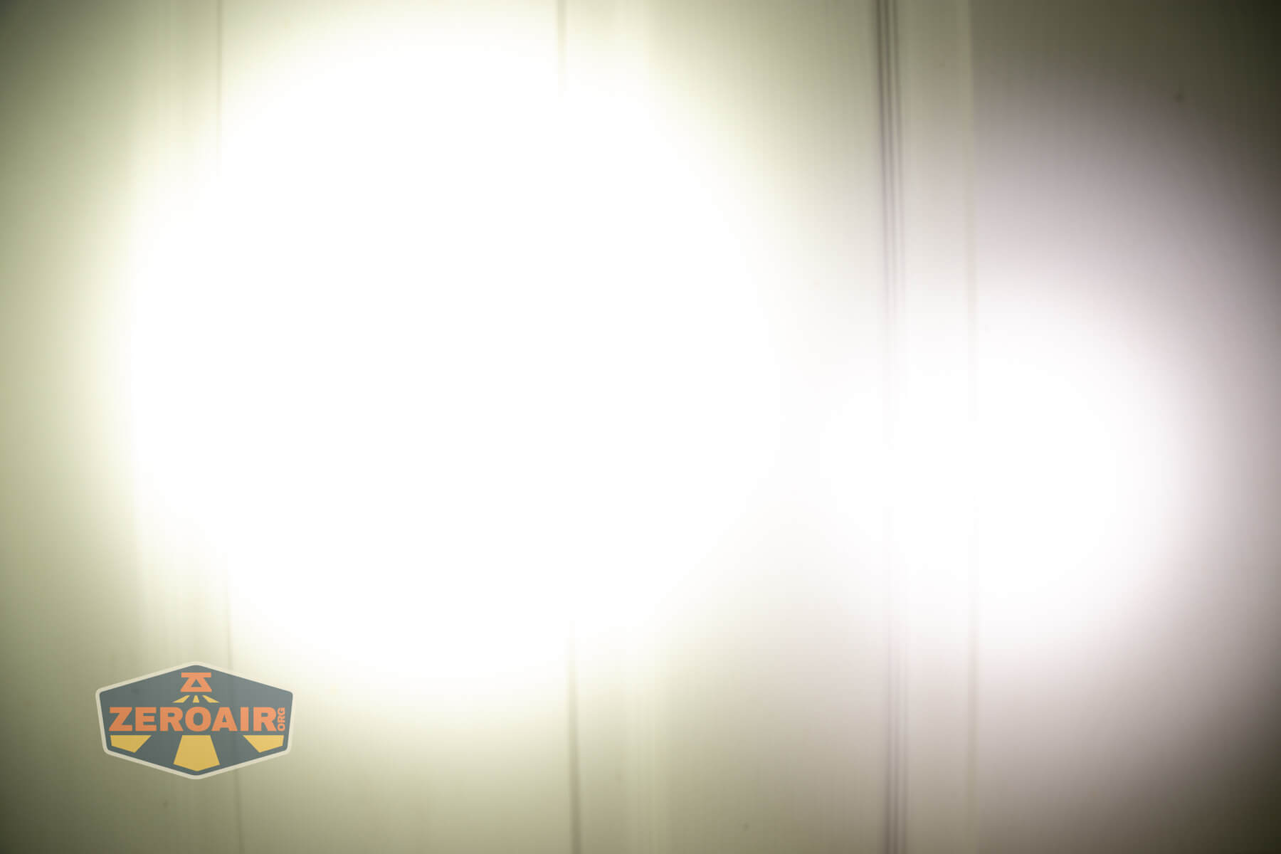 Skilhunt EC200 SFT25R flashlight beamshots on door (at 1') compared to nichia 219b 4500K