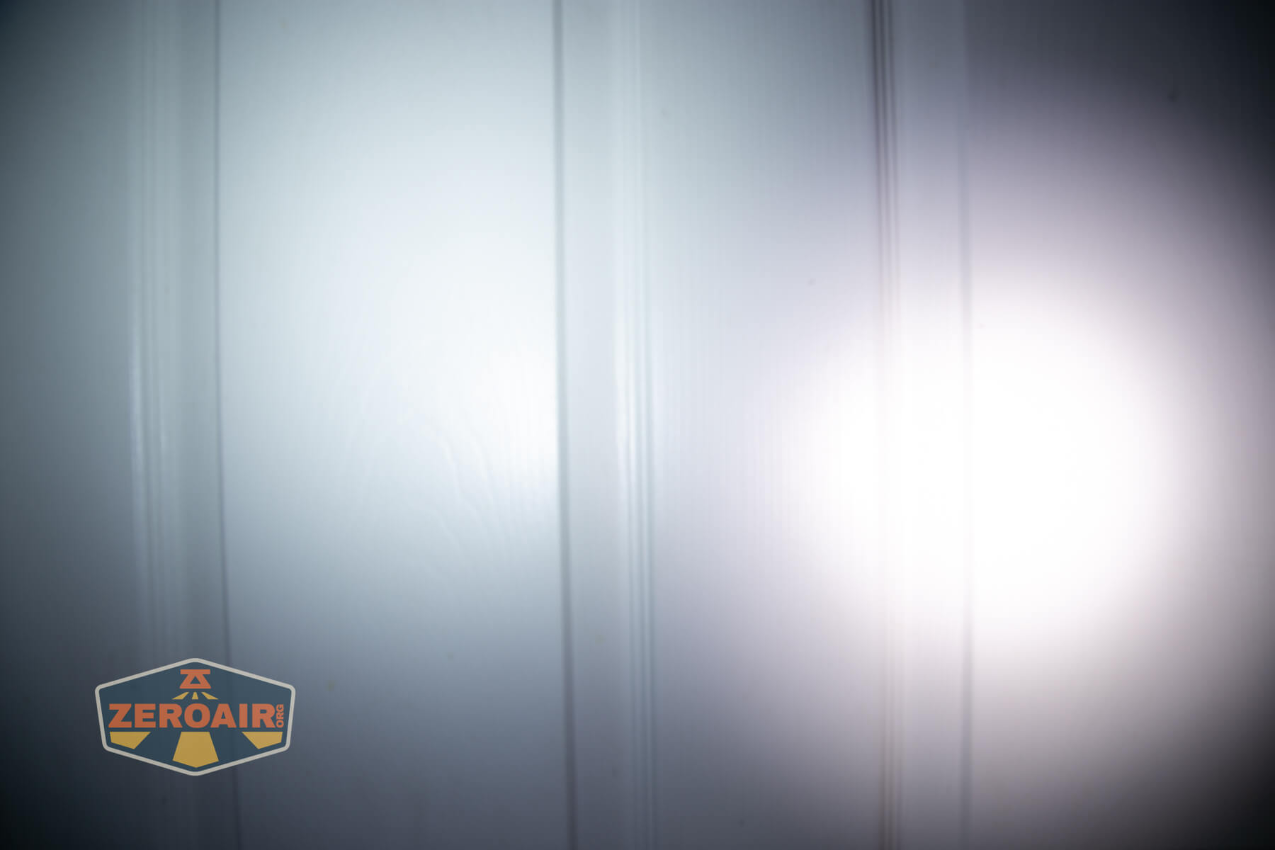 Sofirn ST10 Clip-on mini flashlight beamshots on door compared to nichia 219b