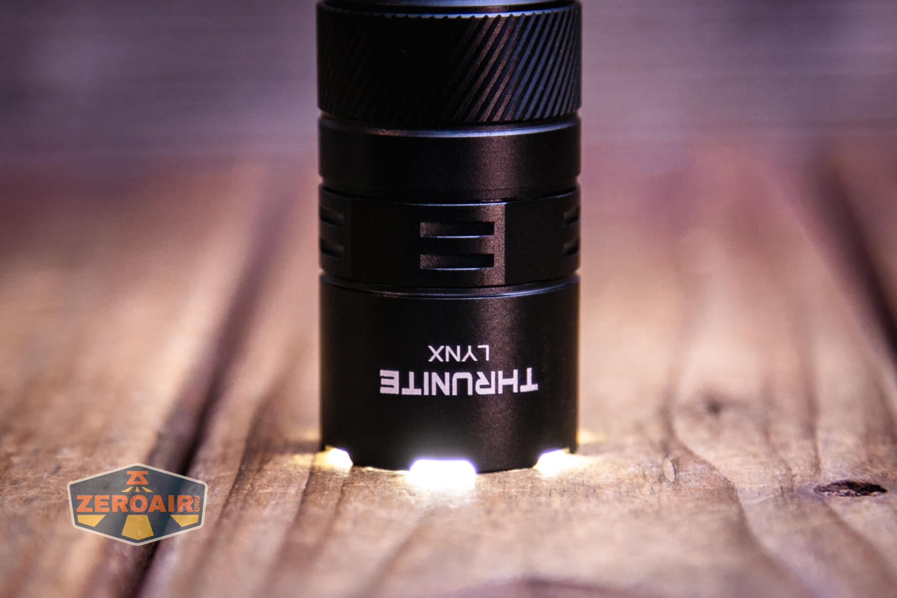 Thrunite Lynx flashlight emitter on while headstanding