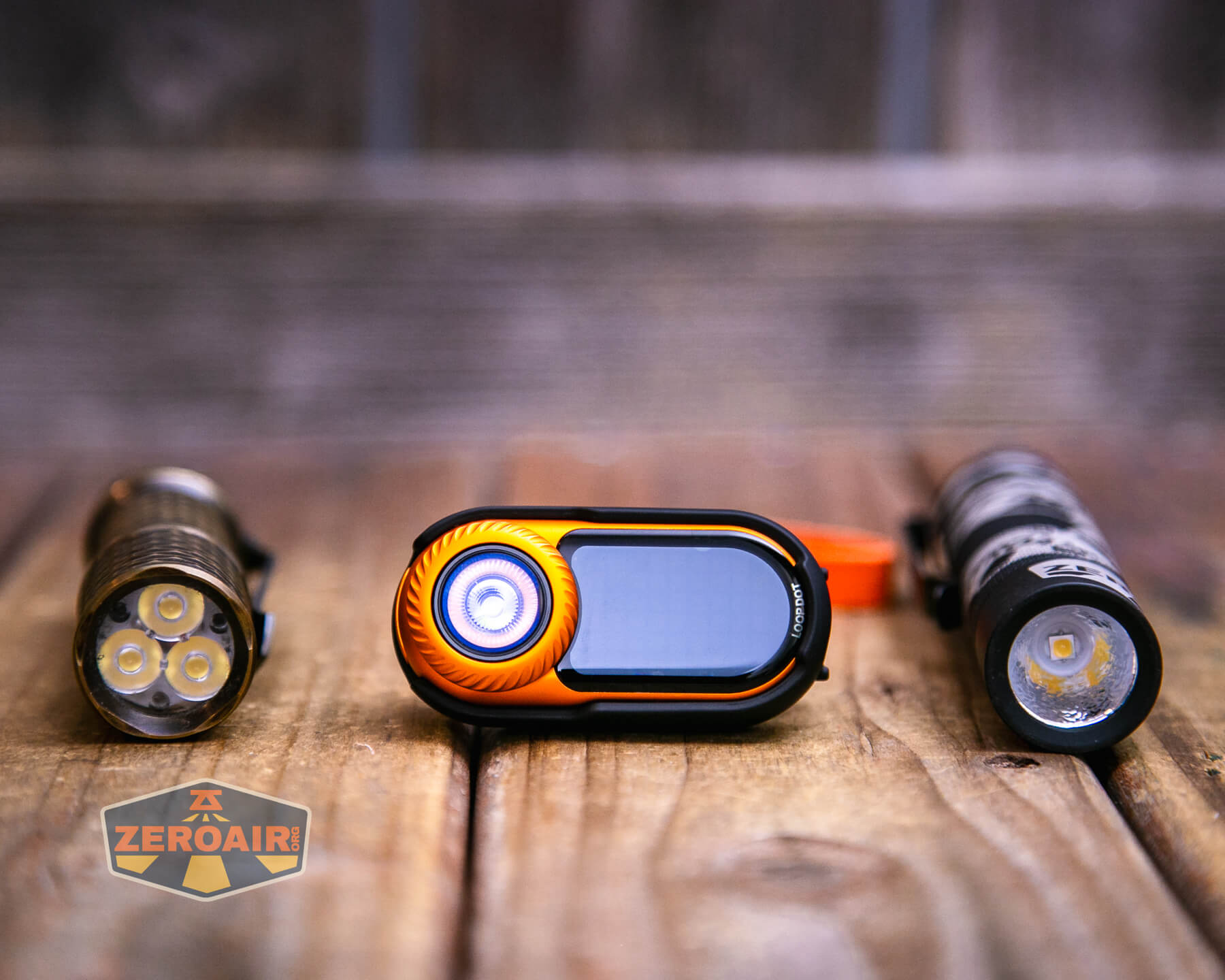 LoopGear LoopDot Orange Pixel Display EDC flashlight with two standard sized flashlights