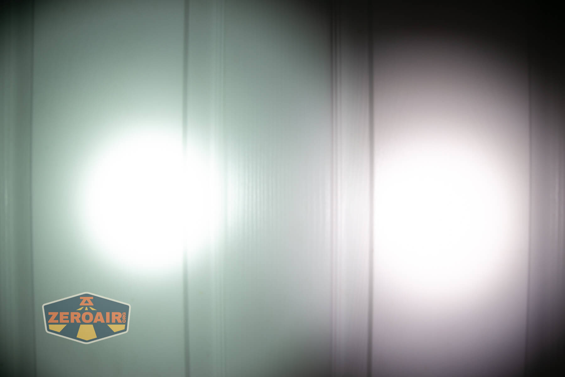 Nitecore EDC17 flat EDC flashlight beamshots on door compared to Nichia 219b