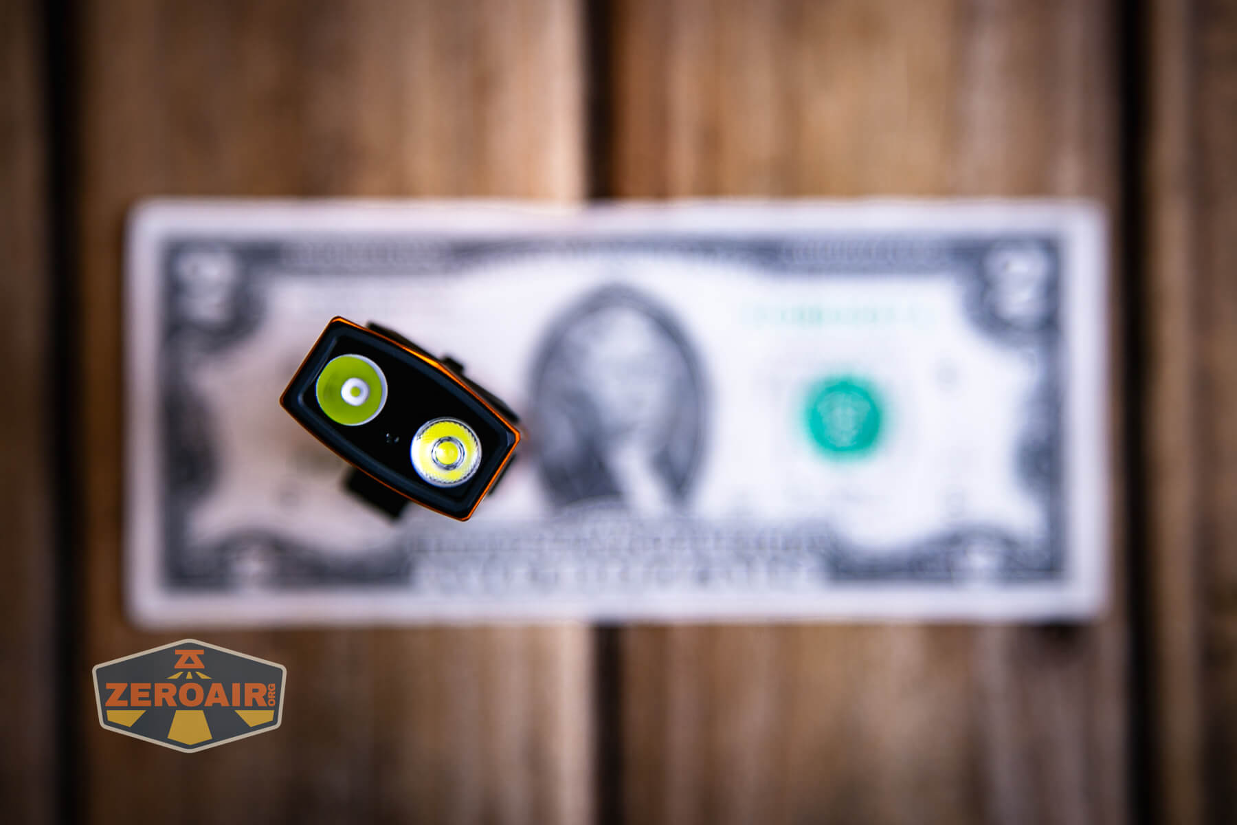 Olight ArkPro Orange flashlight on two dollar bill