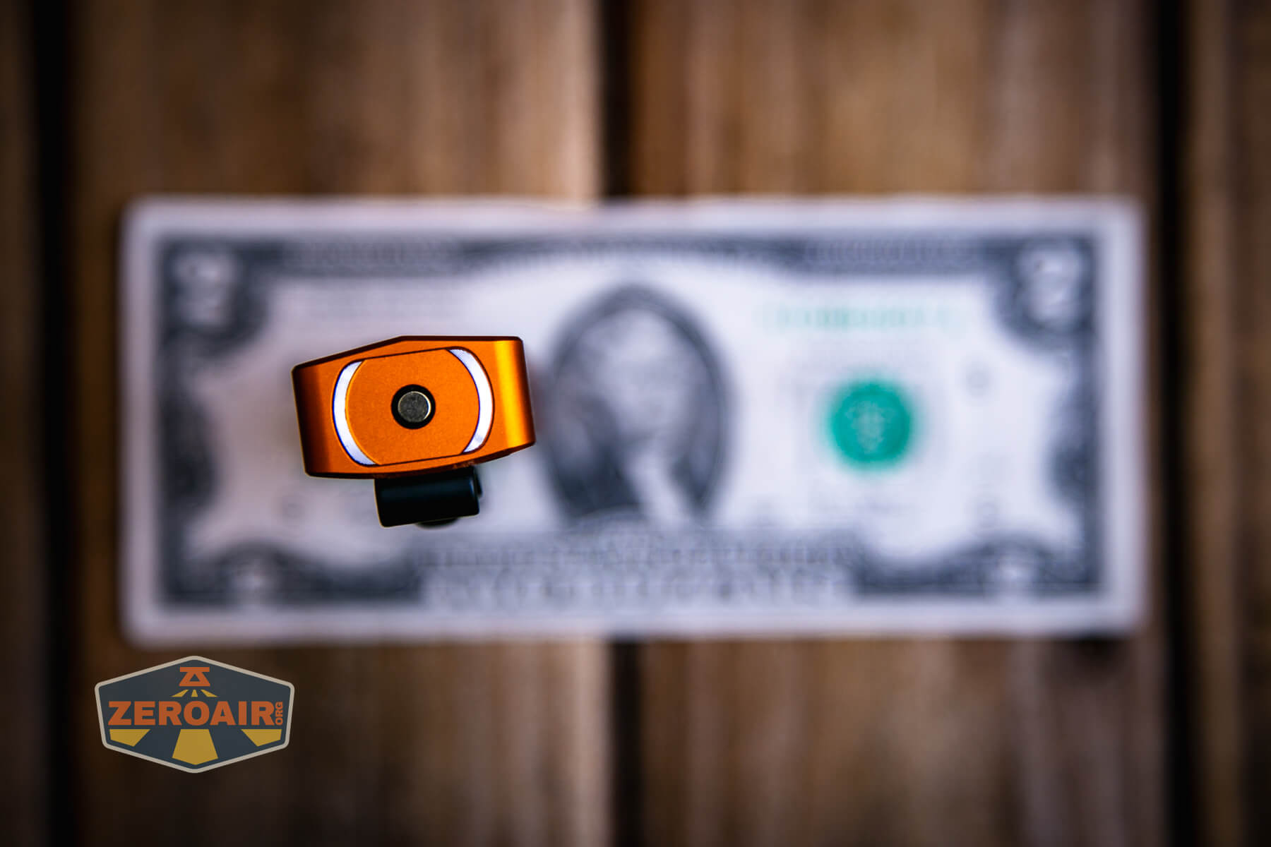 Olight ArkPro Orange flashlight on two dollar bill