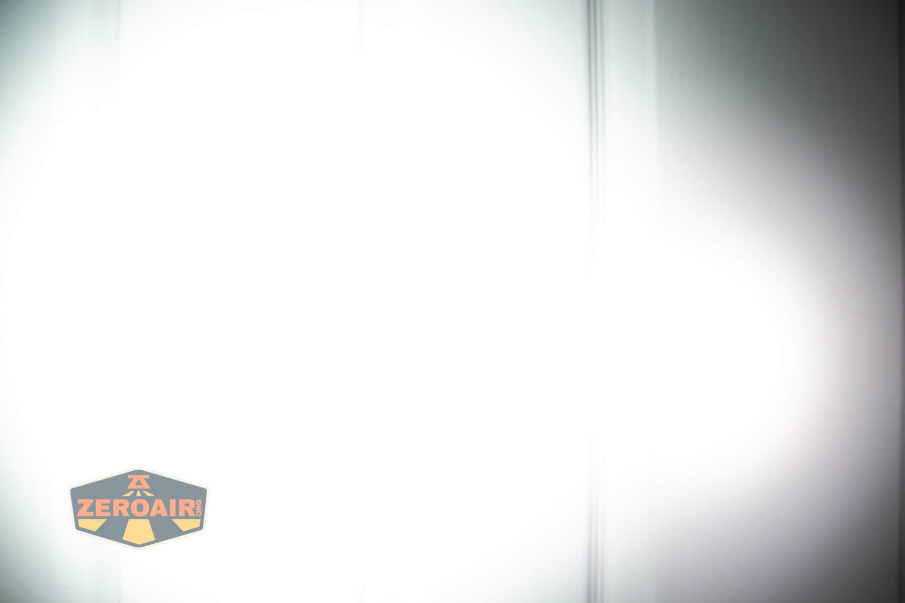 Olight ArkPro Ultra flat EDC flashlight beamshots on door compared to Nichia 219b