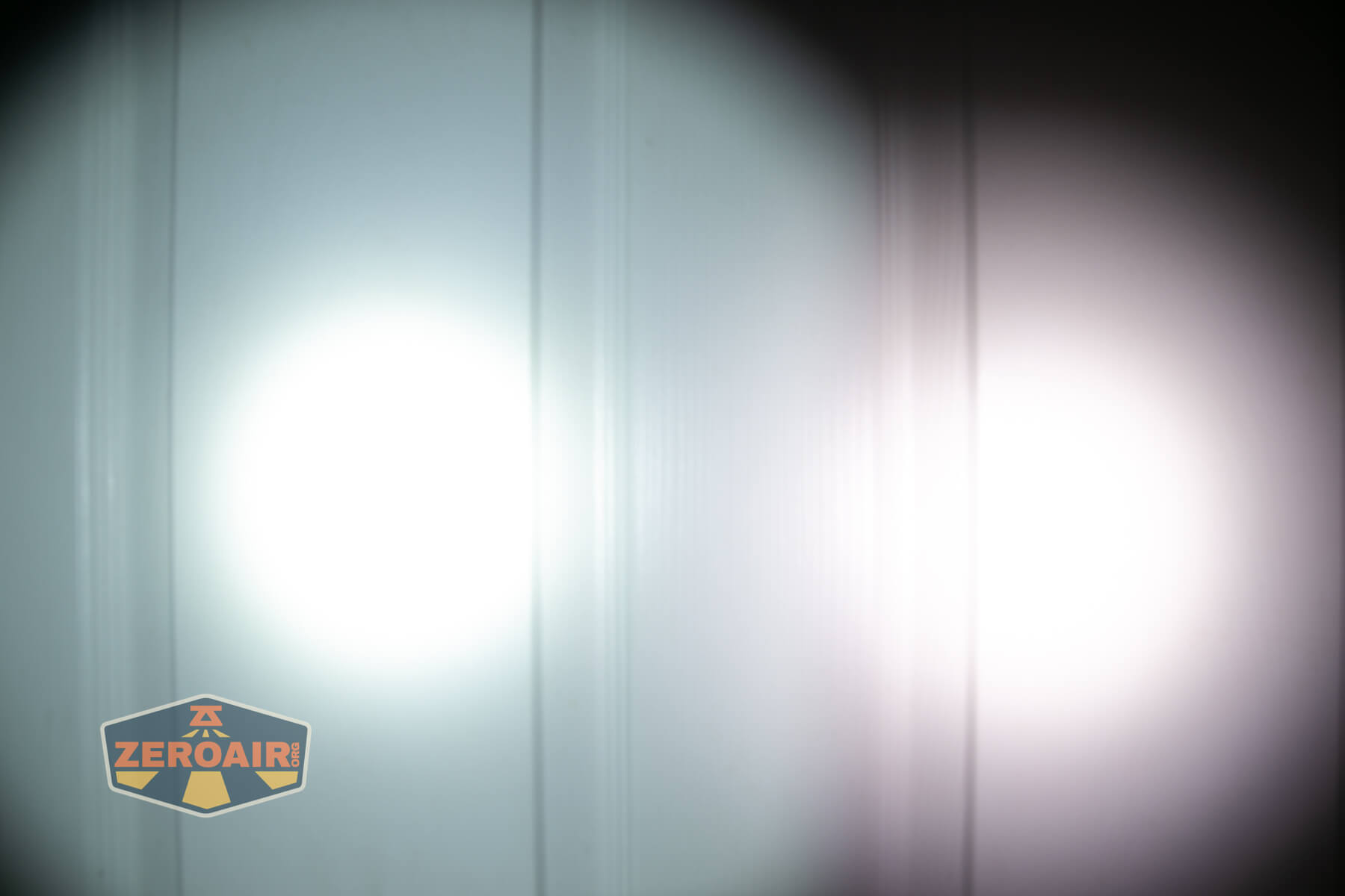 Olight ArkPro Ultra flat EDC flashlight beamshots on door compared to Nichia 219b