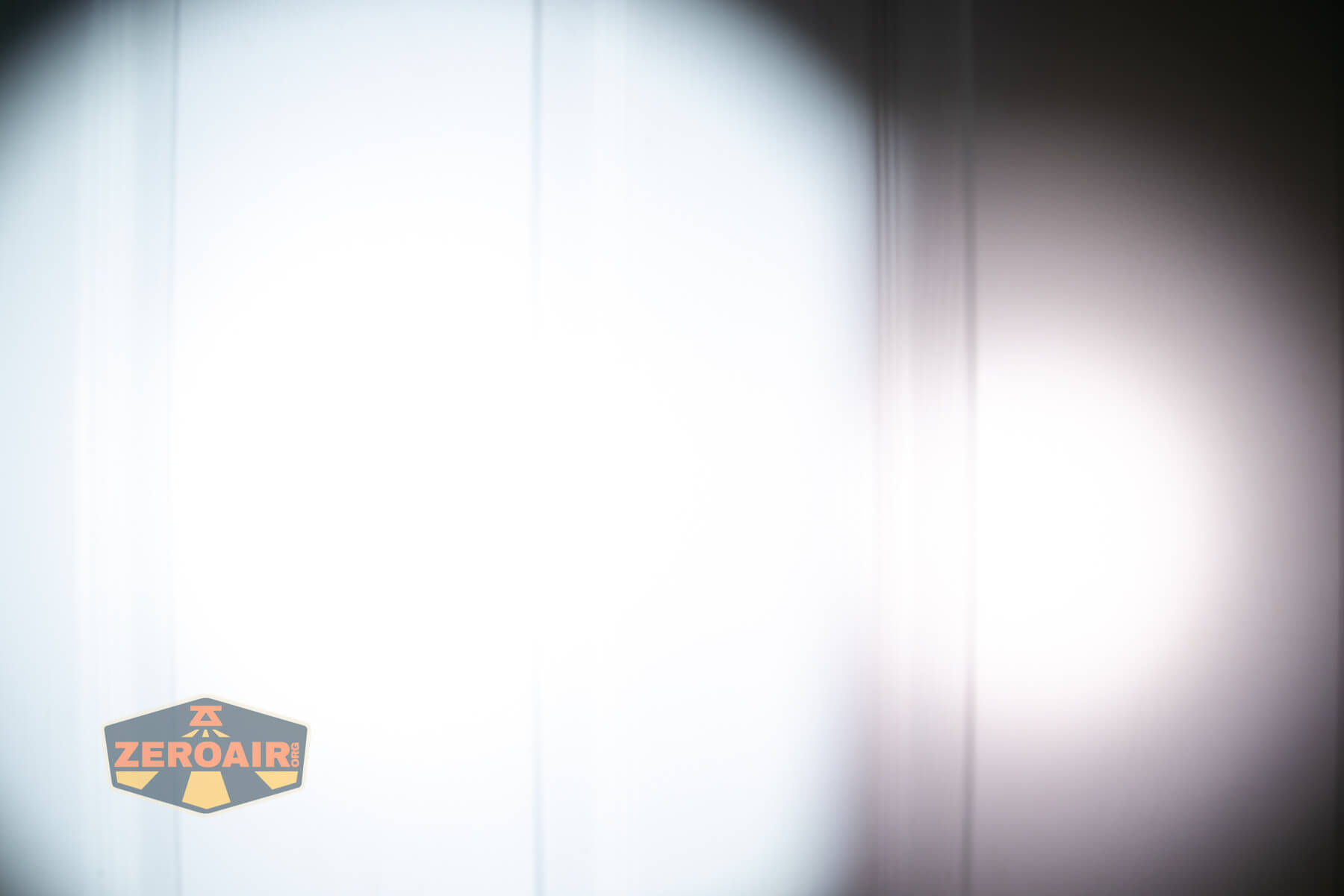 Olight ArkPro Ultra flat EDC flashlight beamshots on door compared to Nichia 219b