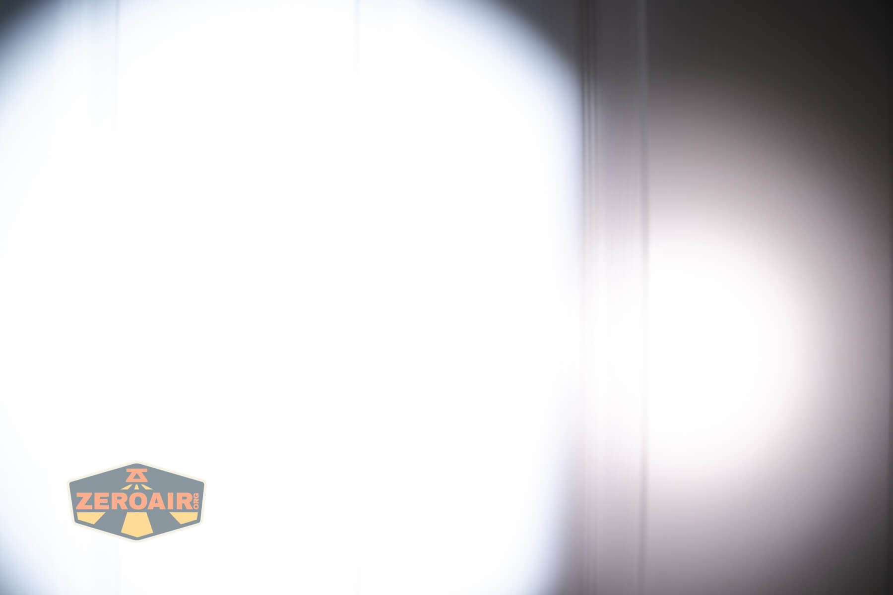 Olight ArkPro Ultra flat EDC flashlight beamshots on door compared to Nichia 219b