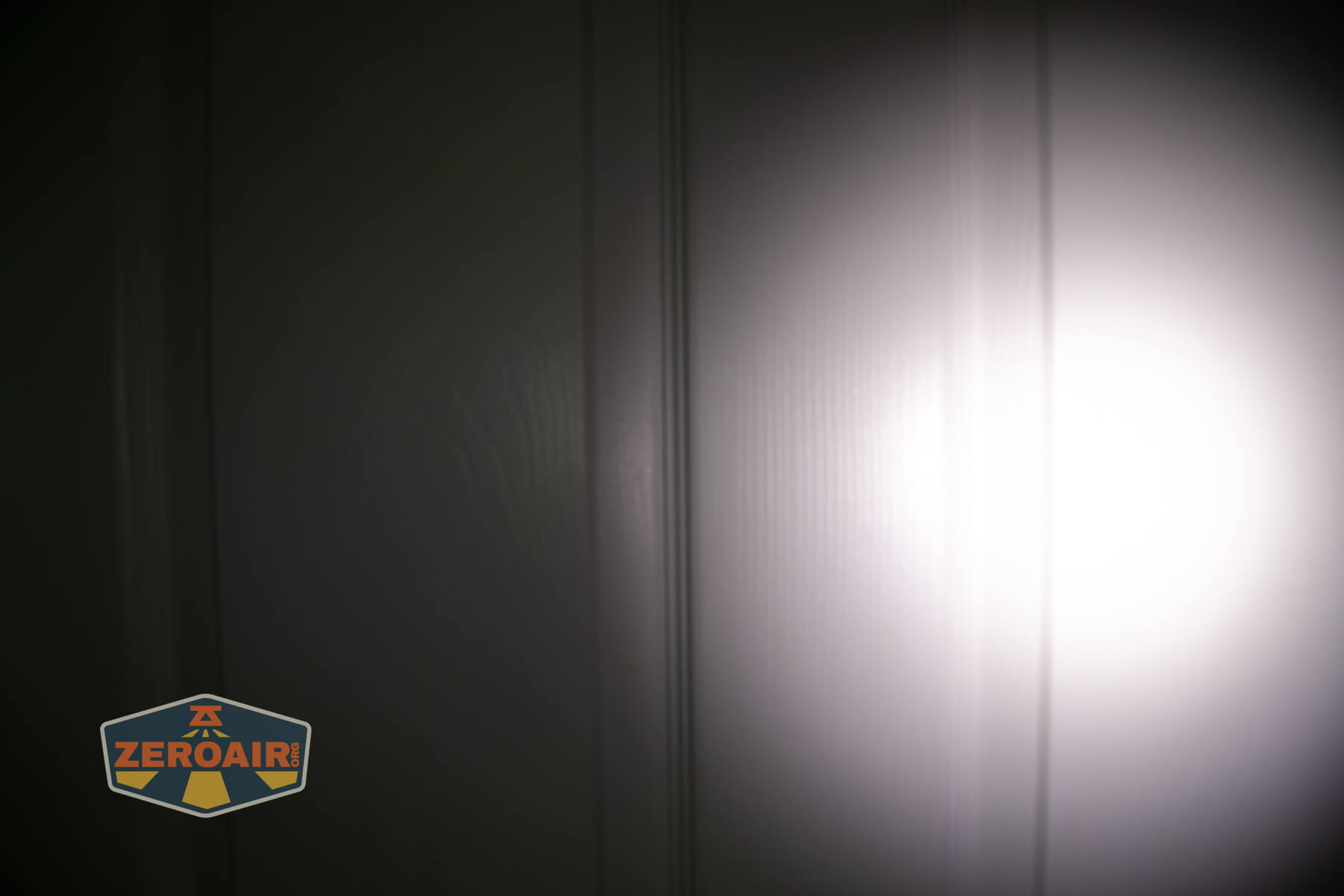 Olight Marauder Mini 2 Compact powerful flashlight beamshots on door compared to nichia 219b
