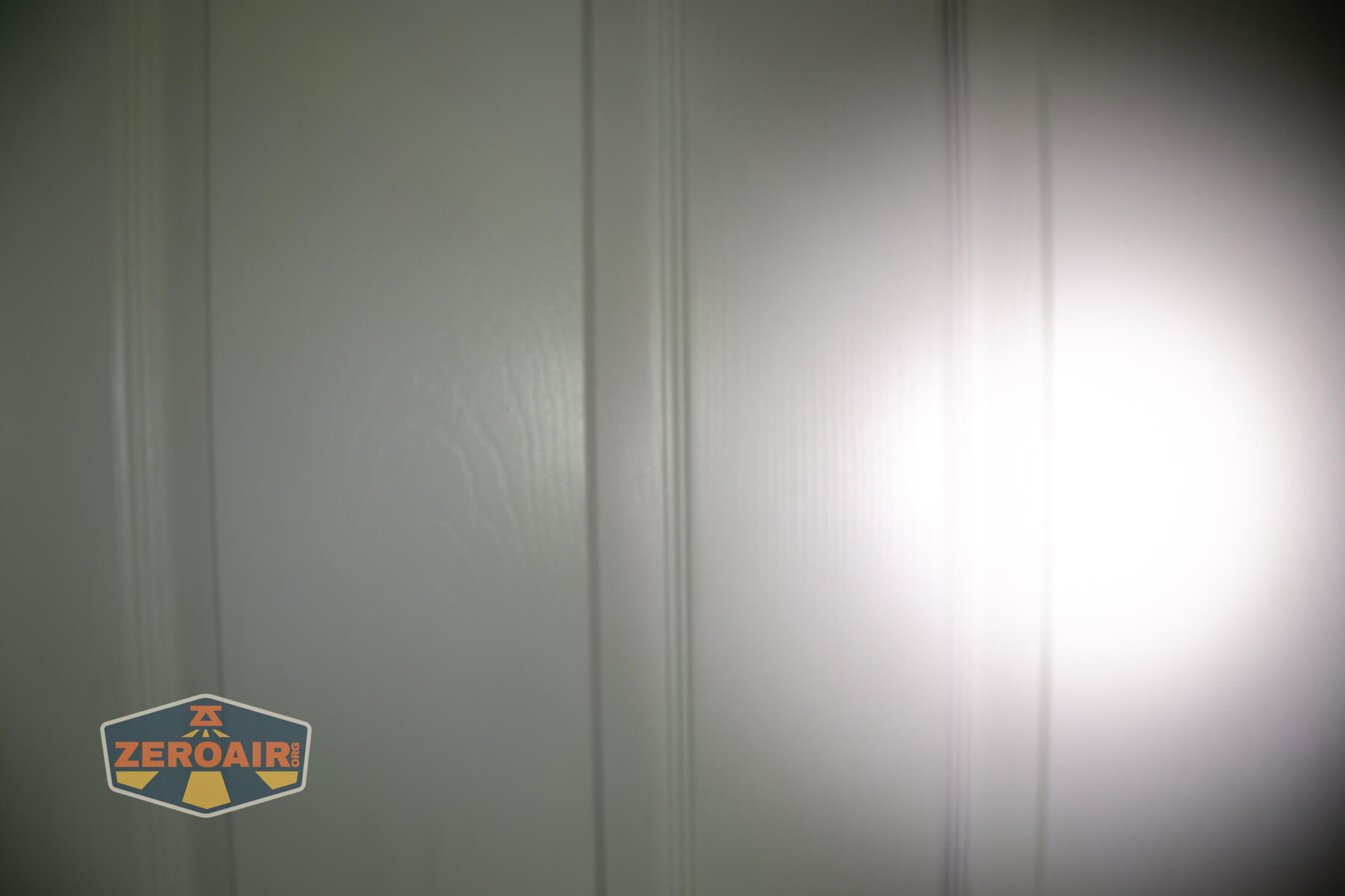 Olight Marauder Mini 2 Compact powerful flashlight beamshots on door compared to nichia 219b