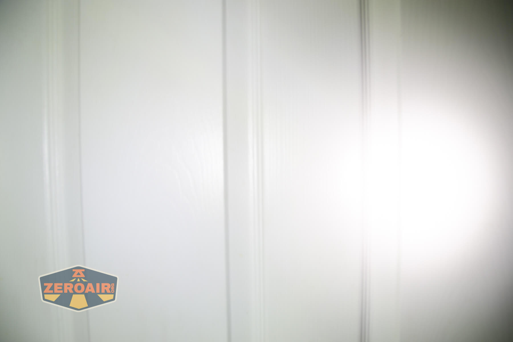 Olight Marauder Mini 2 Compact powerful flashlight beamshots on door compared to nichia 219b