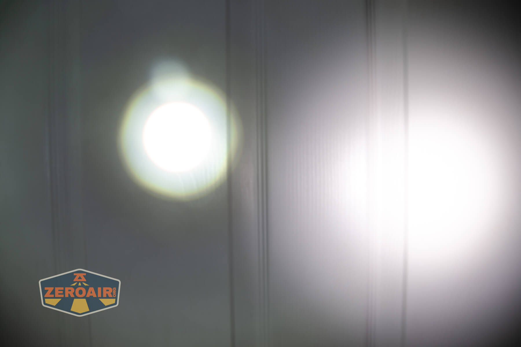 Olight Marauder Mini 2 Compact powerful flashlight beamshots on door compared to nichia 219b