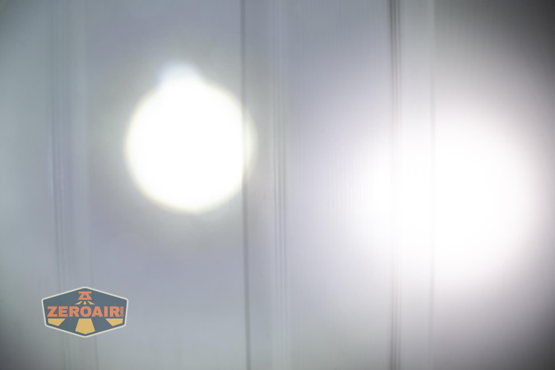 Olight Marauder Mini 2 Compact powerful flashlight beamshots on door compared to nichia 219b